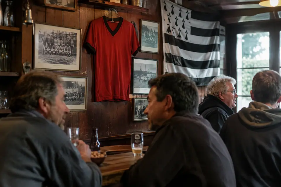 Maillot de foot rouge à col noir de style rétro accroché au mur d'un petit bar breton