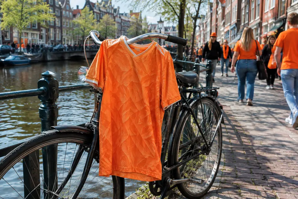 Maillot de foot orange rétro accroché au guidon d'un vélo au bord d'un canal