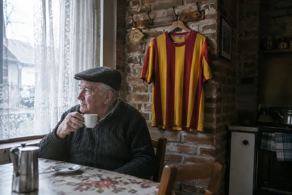Maillot de foot rétro à rayures rouges et jaunes accroché dans la cuisine d'une maison de mineur