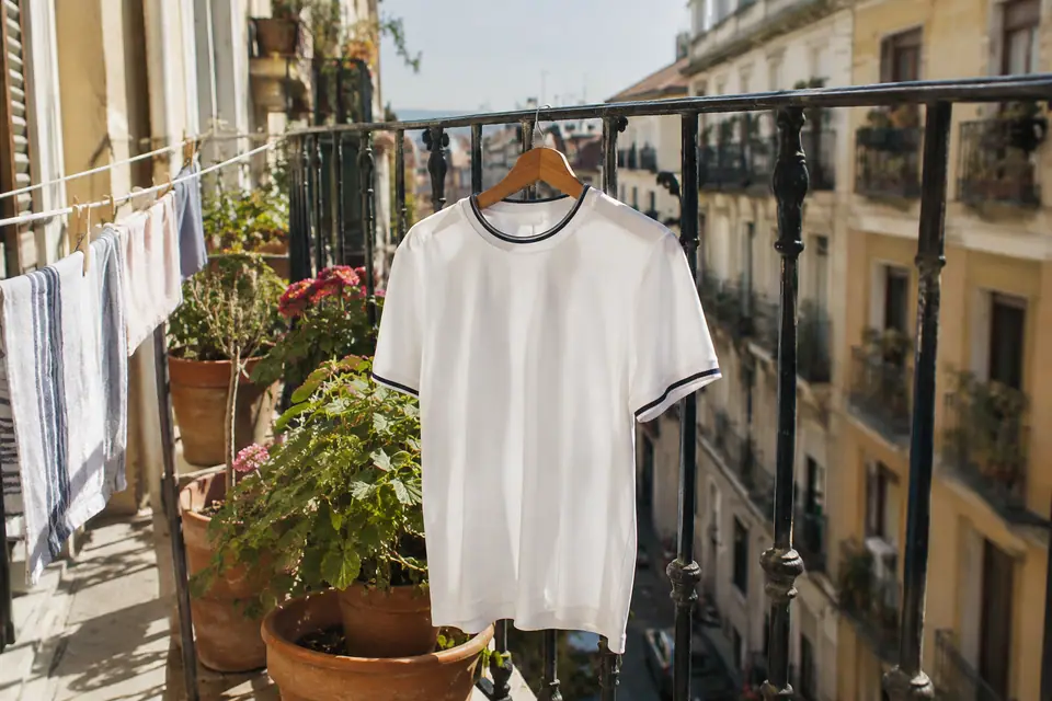 Maillot de foot blanc de style rétro suspendu au balcon ensoleillé d'un vieil immeuble madrilène