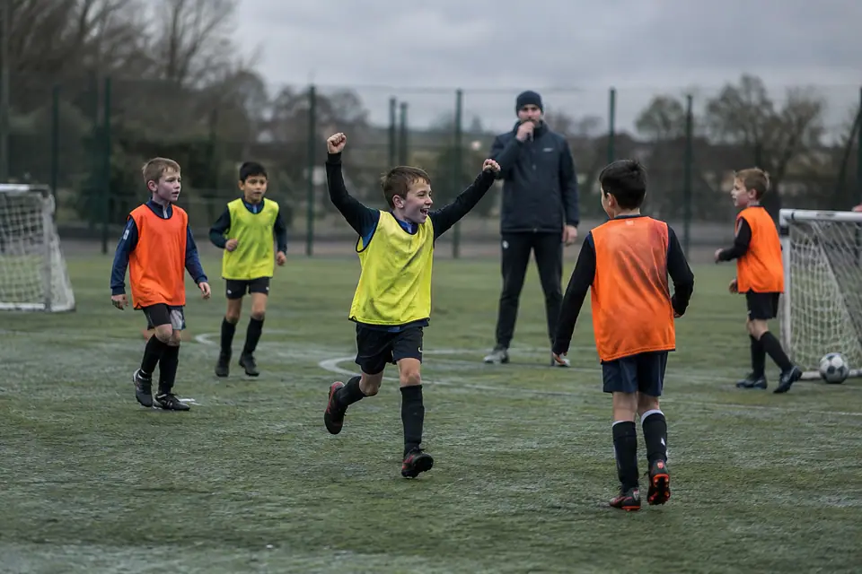 Enfants en chasubles jouant un petit match à quatre contre quatre sur deux mini buts pop-up