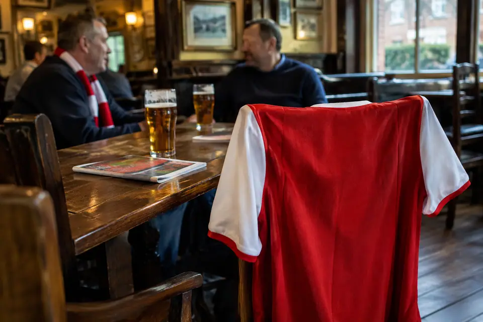 Maillot de foot rouge à manches blanches posé sur une chaise dans un pub londonien