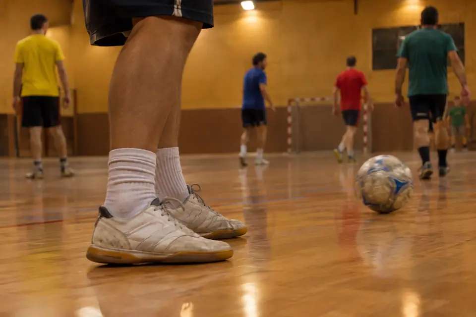 Chaussures de salle usées sur le parquet d'un gymnase pendant une séance de futsal amateur